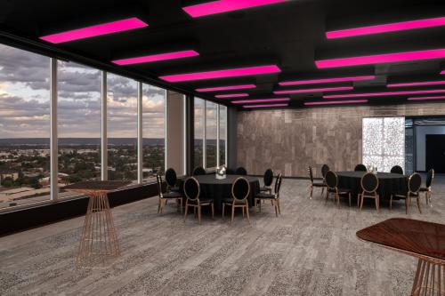 a conference room with tables and chairs and purple lights at Aloft Perth in Perth