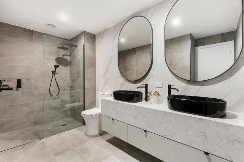 a bathroom with a sink and a mirror at Fitzroy North Apartments by Urban Rest in Melbourne