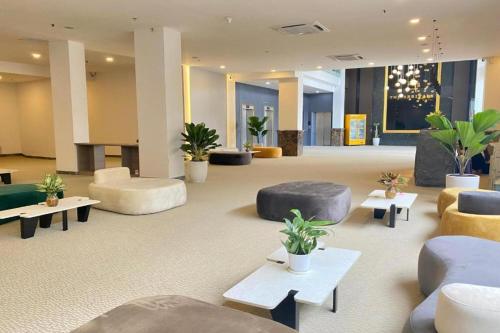 a large lobby with couches and tables and plants at The Arrivals Hotel in Ho Chi Minh City