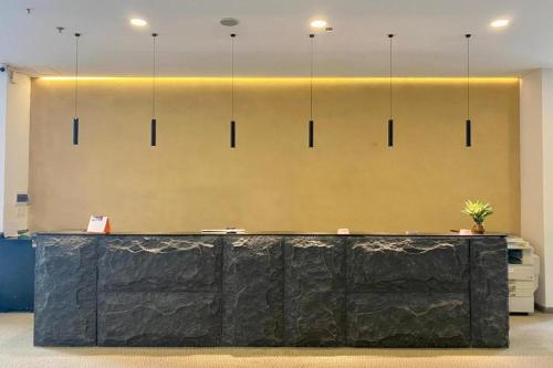 a lobby with a black counter and a wall with lights at The Arrivals Hotel in Ho Chi Minh City