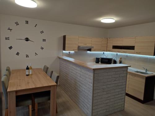a kitchen with a table and a clock on the wall at Ubytování U Venci in Valtice