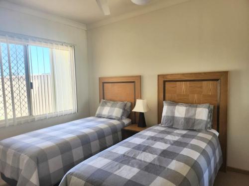 two beds sitting next to each other in a room at Unit 59 Seafront Estate in Jurien Bay