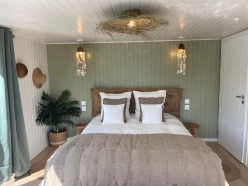 ein Schlafzimmer mit einem großen Bett mit weißen Kissen in der Unterkunft Gîte Seine & Nature Le Capitaine in Bennecourt