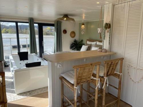 - une cuisine avec un comptoir et des chaises dans la chambre dans l'établissement Gîte Seine & Nature Le Capitaine, à Bennecourt