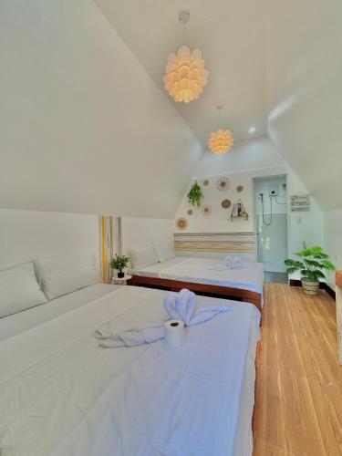 a bedroom with a large white bed with a candle on it at Villa Lovi Panagsama Beach Moalboal in Moalboal