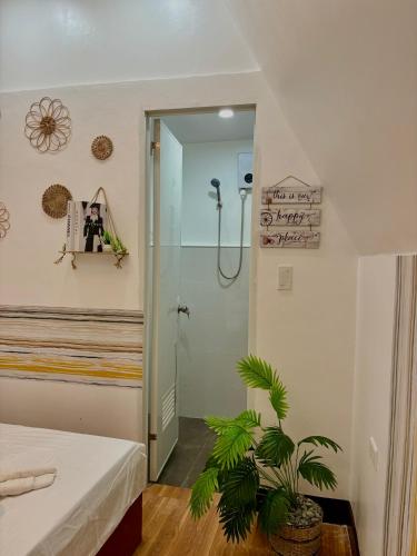 a bathroom with a shower and a potted plant at Villa Lovi Panagsama Beach Moalboal in Moalboal