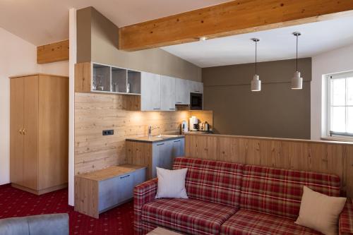 a living room with a couch and a kitchen at Arlen Lodge Appartement in Sankt Anton am Arlberg