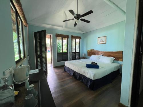 a bedroom with a bed and a ceiling fan at 1511 Coconut Grove in Tioman Island