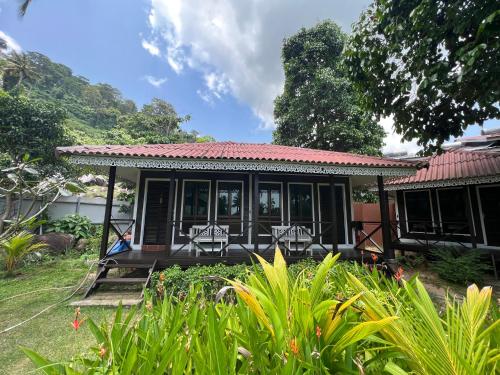 a small house with a porch and chairs at 1511 Coconut Grove in Tioman Island