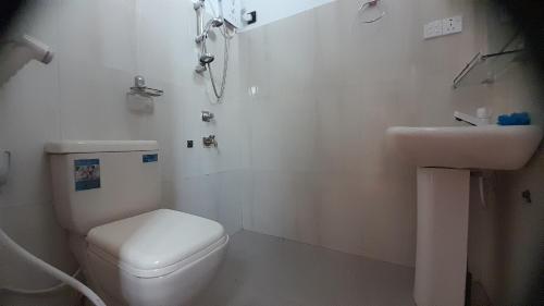 Baño blanco con aseo y lavamanos en Royal Rich Villa Maskeliya, en Maskeliya