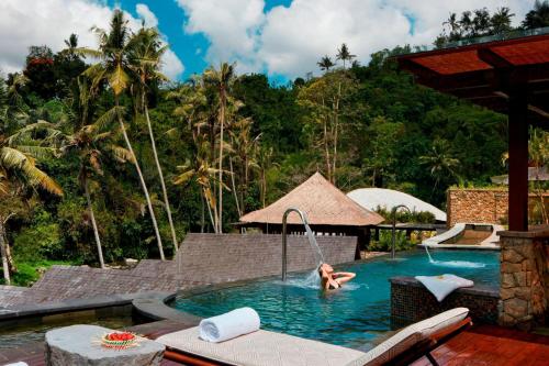 a woman in a swimming pool at a resort at Mandapa, a Ritz-Carlton Reserve in Ubud