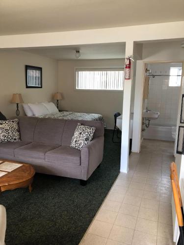 a living room with a couch and a bed at Sun Beach Motel in Osoyoos