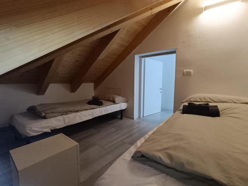 a attic room with two beds and an open door at Apartaments and Rooms Claudia Augusta in Bolzano