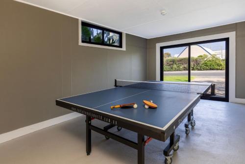 a ping pong table in a living room with at Seaview I Pet Friendly with Stunning Views I 1 Min to Beach in Culburra Beach