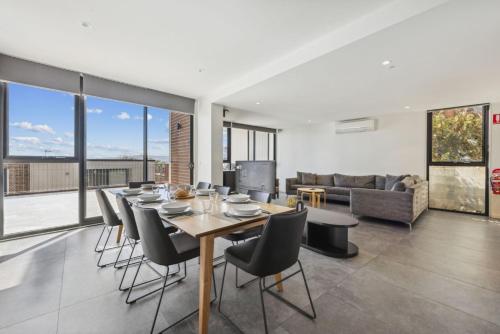 a dining room with a table and chairs and a couch at Chilam C in Jindabyne