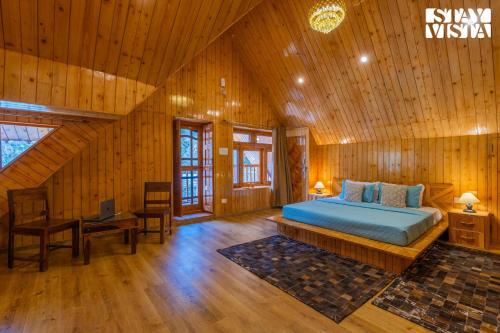 a bedroom with a bed in a wooden room at StayVista at Wisteria Whispers with Bonfire & River View in Gushaini