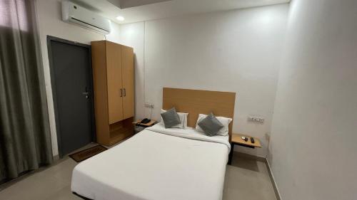 1 dormitorio con 1 cama blanca grande en una habitación en Maharastra Bhavan Atithi Grah en Naimishāranya