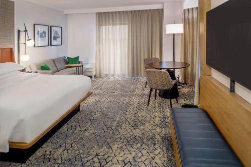 a hotel room with a bed and a table at Sheraton Westport Plaza in Maryland Heights