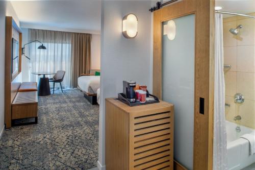 a hotel room with a bed and a bathroom at Sheraton Westport Plaza in Maryland Heights