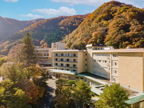 a view of a building with mountains in the background at KAMENOI HOTEL Akita Yuze in Kazuno