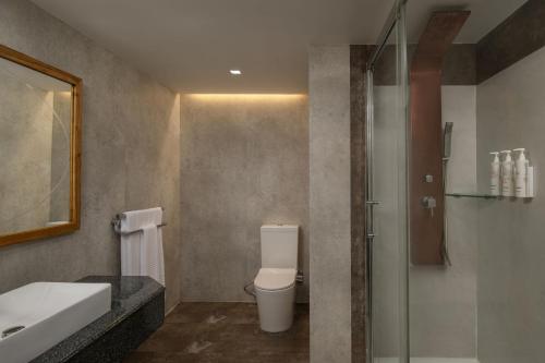een badkamer met een toilet, een wastafel en een douche bij Delta Hotels by Marriott Dar es Salaam in Dar es Salaam