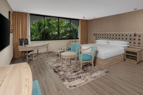 Delta Hotels by Marriott Dar es Salaam في دار السلام: غرفة فندقية بسرير وطاولة وكراسي