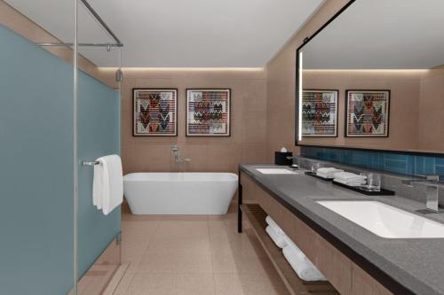a bathroom with two sinks and a bath tub at Four Points by Sheraton Palawan Puerto Princesa in Sabang