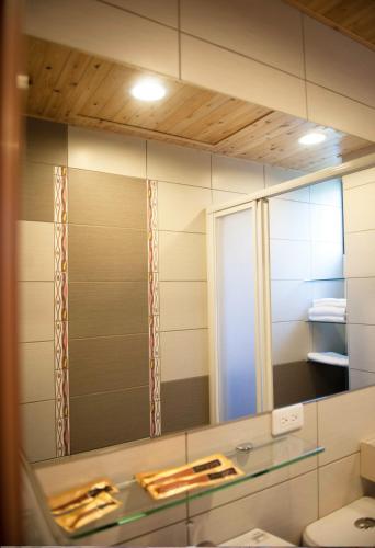 a mirror in a bathroom with a sink at Rowan House in Taichung