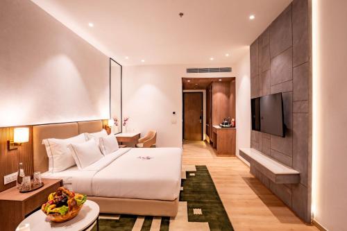a hotel room with a bed and a television at Velmore Kasauli Operated by Royal Orchid Hotel Ltd. in Kasauli