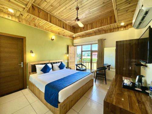 a bedroom with a bed and a desk and a television at Hotel Corbett Bunglow By Food Bunglow in Rāmnagar
