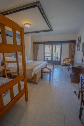 a bedroom with two bunk beds and a balcony at PrideInn Flamingo Beach Resort & Spa Mombasa in Mombasa