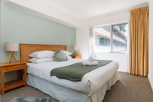 um quarto com uma cama grande e uma janela em Canberra 1-Bed with Pool, Gym, BBQ & Tennis Court em Camberra