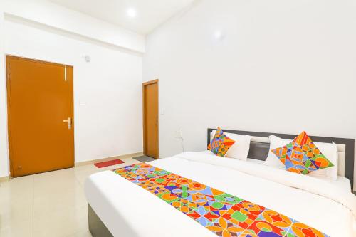 a bedroom with a large bed with colorful pillows at FabHotel Trayamb in Ayodhya