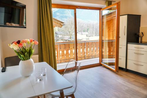 a kitchen with a table with a vase of flowers on it at Ferienwohnungen Quellenhof in Bad Reichenhall