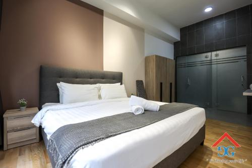 a bedroom with a large bed with white sheets at Astoria Ampang By Grabstay in Kuala Lumpur