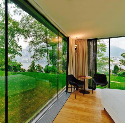 a room with large windows and a table and chairs at Casa Sull'Albero in Malgrate
