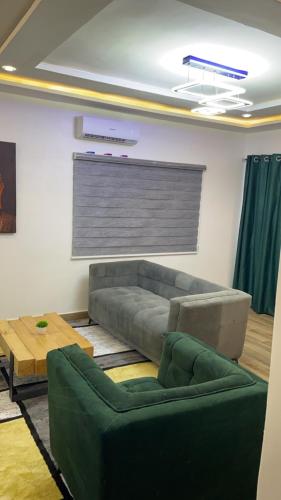 a living room with a green couch and a table at Zen home in Cotonou