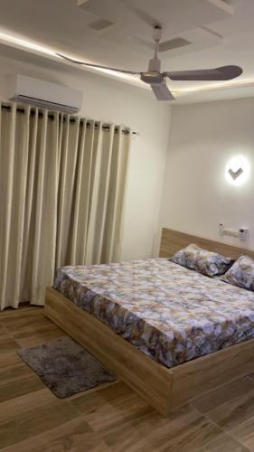 1 dormitorio con 1 cama y ventilador de techo en Zen home, en Cotonou