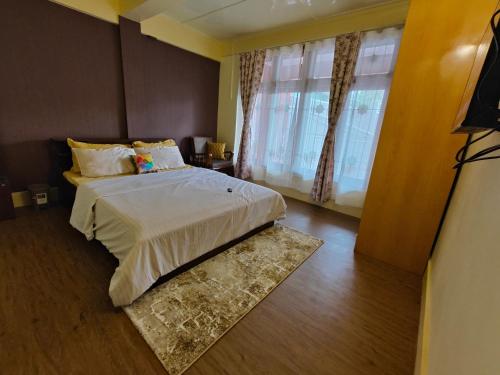 um quarto com uma cama grande e uma janela em Meraki Homestay em Shillong