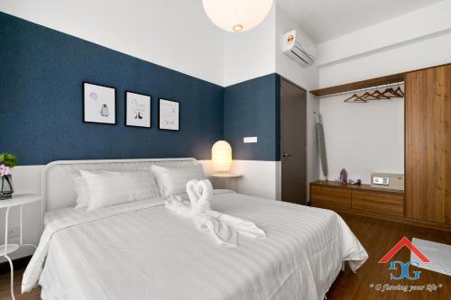 a bedroom with a white bed with a stuffed animal on it at Astoria Ampang By Grabstay in Kuala Lumpur