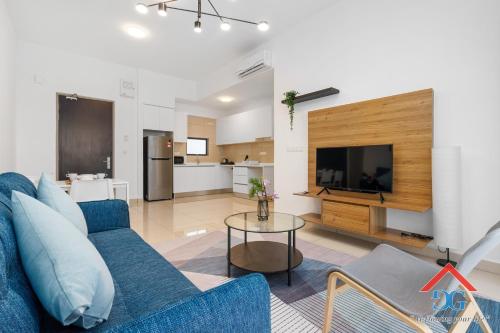 a living room with a blue couch and a television at Astoria Ampang By Grabstay in Kuala Lumpur