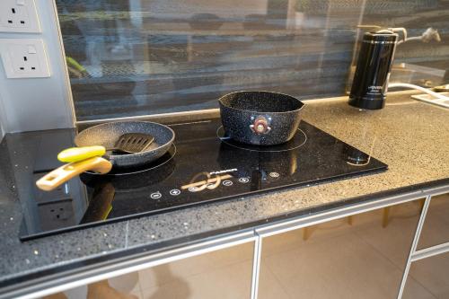 a kitchen counter with two pots and pans on a stove at Seaview Urban suites Georgetown @Penang in Jelutong