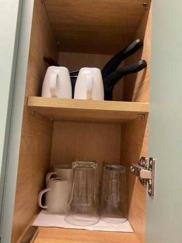 a cupboard with cups and other kitchen utensils at City Vibe-Sigrou 44 in Thessaloniki