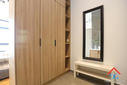 a dressing room with a wooden cabinet and a mirror at Astoria Ampang By Grabstay in Kuala Lumpur