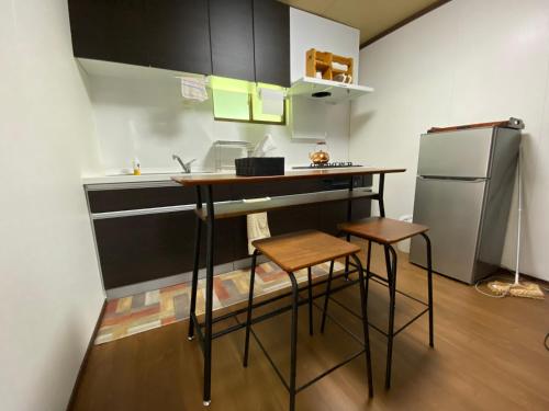 a small kitchen with a counter and a refrigerator at 民泊 あざし はなれ1棟貸し 母屋 2部屋貸 Open in January 2024, Minpaqu Azashi in Kushimoto