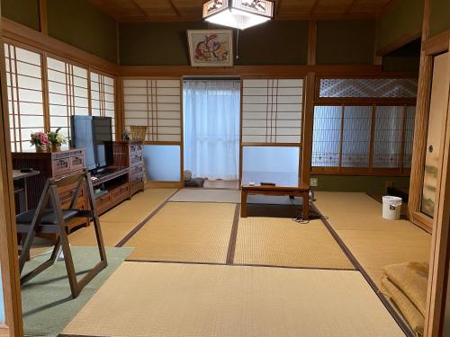 a room with a room with a table and a tv at 民泊 あざし はなれ1棟貸し 母屋 2部屋貸 Open in January 2024, Minpaqu Azashi in Kushimoto