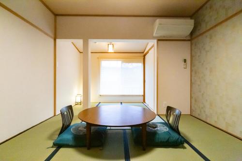 a room with a table and chairs in it at Ryokan Fukinoya in Yufuin