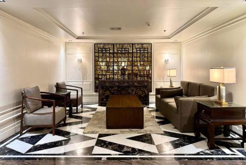 a living room with a couch and chairs and a table at Grand Regal Hotel Davao in Davao City