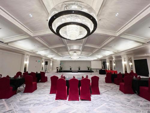 a large room with red chairs and a large chandelier at Grand Regal Hotel Davao in Davao City
