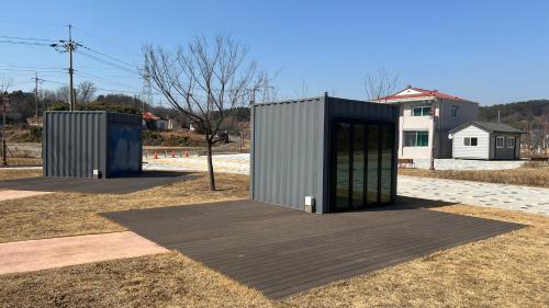 a building with doors on a field with a house at Starium Seocheon in Seocheon